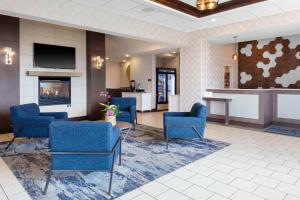 a lobby with blue chairs and a fireplace at Homewood Suites by Hilton St. Louis - Galleria in Richmond Heights