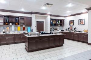 a large kitchen with brown cabinets and counters at Homewood Suites by Hilton St. Louis - Galleria in Richmond Heights