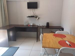 Habitación con escritorio, mesa y sillas. en @Home BnB en Maseru