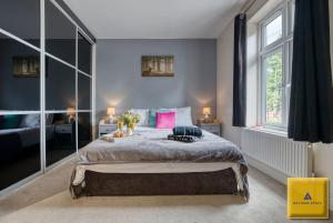 コベントリーにある4 Bedroom, 6 Beds, 3 Bathrooms, Near NEC & Birmingham Airport, Business, Contractor and Family Friendly, Free Wi-Fi, Free Parkingのピンクの枕が付いた大きなベッドのある寝室