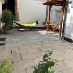 d'une terrasse avec un hamac, une table et des chaises. dans l'établissement WALDWERK am Wasserfall, à Triberg
