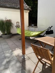 - un hamac sur une terrasse avec une table et une chaise dans l'établissement WALDWERK am Wasserfall, à Triberg