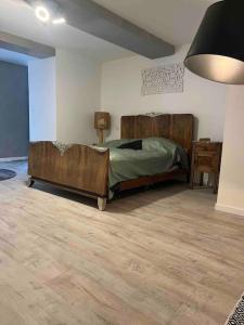 1 dormitorio con 1 cama con cabecero de madera en Chez Kikou, en Sisteron