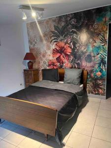 1 dormitorio con 1 cama con una pared colorida en Chez Kikou, en Sisteron
