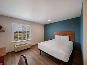 ein Schlafzimmer mit einem großen Bett und einem Fenster in der Unterkunft WoodSpring Suites Fort Worth Trophy Club in Trophy Club