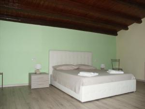 a bedroom with a white bed and a green wall at Il soppalco in Avola