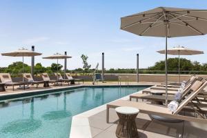 - une piscine avec des chaises longues et des parasols dans l'établissement Doubletree By Hilton Abilene Downtown Convention Center, à Abilene
