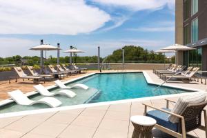 einen Pool mit Liegestühlen und ein Gebäude in der Unterkunft Doubletree By Hilton Abilene Downtown Convention Center in Abilene