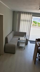 a living room with a couch and a table at Cozy studio near the park with huge verandah. in Veliko Tŭrnovo