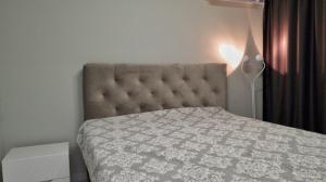 a bedroom with a bed with a headboard and a lamp at Cozy studio near the park with huge verandah. in Veliko Tŭrnovo