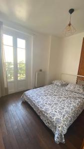 ein Schlafzimmer mit einem Bett und zwei Fenstern in der Unterkunft Charmante maison en ville Paris in Charenton-le-Pont