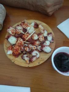 a plate of shrimp on a wooden table at Piso con Encanto en Coruña. in A Coruña