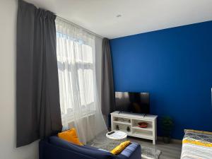 a blue room with a couch and a window at Sofieflat - Wallifornie in Charleroi