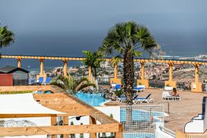 a resort with a swimming pool and palm trees at Cozy 2 Bedroom Apartment in Costa Adeje in Adeje