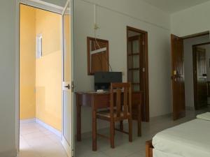 um quarto com uma secretária, um computador e uma cadeira. em Residencial Pôr do Sol em Porto Novo