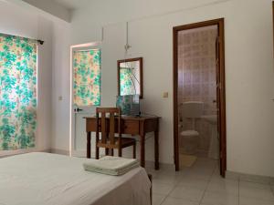 um quarto com uma cama e uma escrivaninha com um computador em Residencial Pôr do Sol em Porto Novo