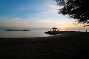 a beach with a group of people and the ocean at Villa Lotus Flower Sanur in Sanur