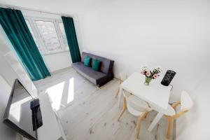 a white living room with a table and a couch at Crystal Apartment Katowice V in Katowice