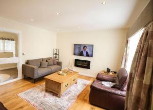 a living room with a couch and a table at Seafront Sanctuary Ballycastle in Ballycastle