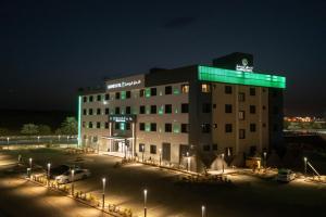 um edifício com luz verde em cima em Karims Hotel em Al Majmaah