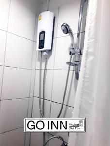 una ducha en un baño con una señal de go inn en GO INN v สนามบิน, en Lat Krabang