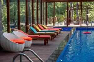 a row of lounge chairs next to a swimming pool at Chillaru Spa & Resort in Kasauli