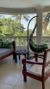 GaluにあるDiani Hideaway Beach Villaのポーチ(椅子付)とブランコ付きの客室です。
