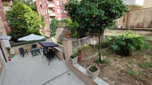 Cet appartement dispose d'une terrasse avec une table et un arbre. dans l'établissement VATICAN GREEN GARDEN, à Rome