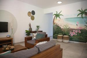 een woonkamer met een bank en een schilderij aan de muur bij Caribbean Happyness in Willemstad