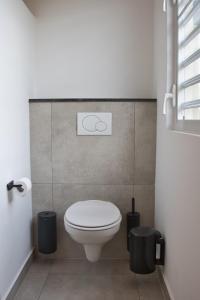 een badkamer met een toilet en 2 vuilnisbakken bij Caribbean Happyness in Willemstad