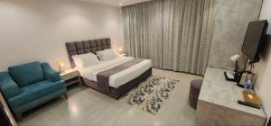 1 dormitorio con 1 cama y 1 silla azul en فندق جرين ليف en Yeda