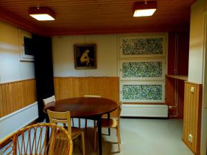 een eetkamer met een houten tafel en stoelen bij Nostalginen residenssi Taika in Varkaus