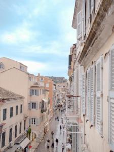 a city street with buildings and people walking down the street at Corfu Liston Old Town Apartment in Corfu Town