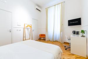 a white bedroom with a white bed and a desk at Starguest Dante in Naples