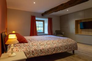 sypialnia z łóżkiem z lampką i oknem w obiekcie Le Temps d'une Fugue w mieście Lierneux