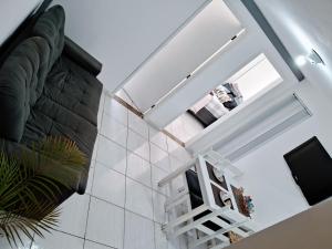 Una escalera en una habitación con azulejos blancos en Solar do Pontal - Lindo Apartamento a 600m da praia, en Río de Janeiro