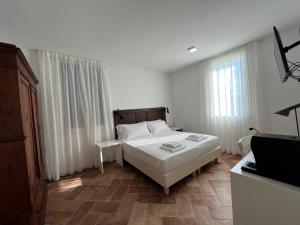 a white bedroom with a bed and a window at AFFITTACAMERE SAN MAMANTE in Santa Lucia delle Spianate