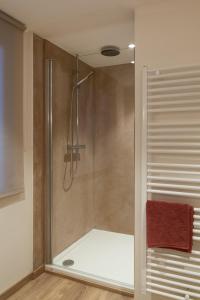 a shower with a glass door in a bathroom at Le Temps d'une Fugue in Lierneux