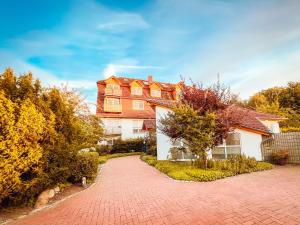 a house with a brick driveway in front of it at Ferienwohnung Sunset bei Warnemünde in Rostock