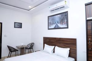 a bedroom with a bed and a table and chairs at Hotel Homeland Inn in Sirsa
