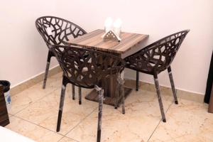 a wooden table and two chairs at a table at Hotel Homeland Inn in Sirsa