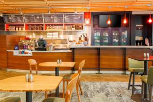 a restaurant with tables and chairs and a counter at Courtyard by Marriott Dallas Arlington South in Arlington