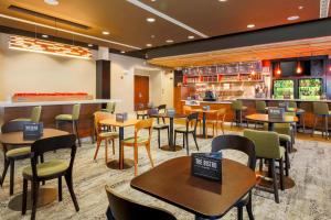 a restaurant with tables and chairs and a bar at Courtyard by Marriott Dallas Arlington South in Arlington