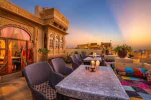 d'une terrasse avec tables et chaises et vue sur la ville. dans l'établissement Hotel Garh Jaisal Haveli, à Jaisalmer