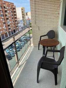 a table and chair on a balcony with a view of a city at Apartment Nautico in Vinarós