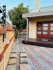 a house with a brick walkway next to a building at Soft petal in Pretoria