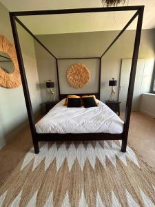 um quarto com uma cama de dossel e um espelho grande em Le Manoir du Monde em Lieu-Saint-Amand
