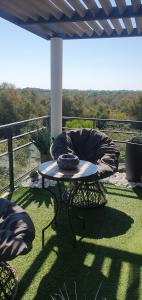 a patio with a table and a chair on a balcony at Appartement de L'Espiguette in Le Grau-du-Roi