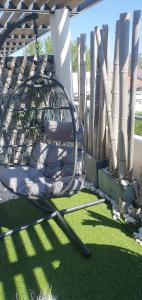a chair sitting on the grass in a yard at Appartement de L'Espiguette in Le Grau-du-Roi
