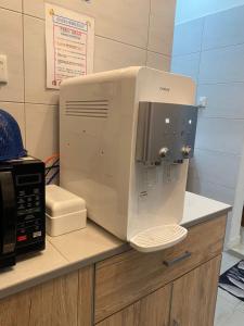 a white microwave sitting on top of a counter at Naira Homestay Kota Bharu ,Wakaf Che Yeh 4 Bilik 3 Aircond in Kota Bharu